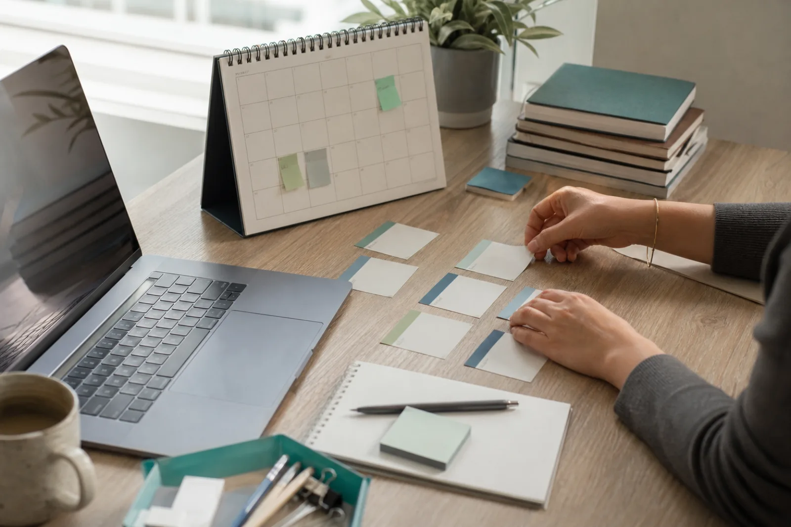 Assessment coordinator planning candidate schedules beside a laptop and calendar